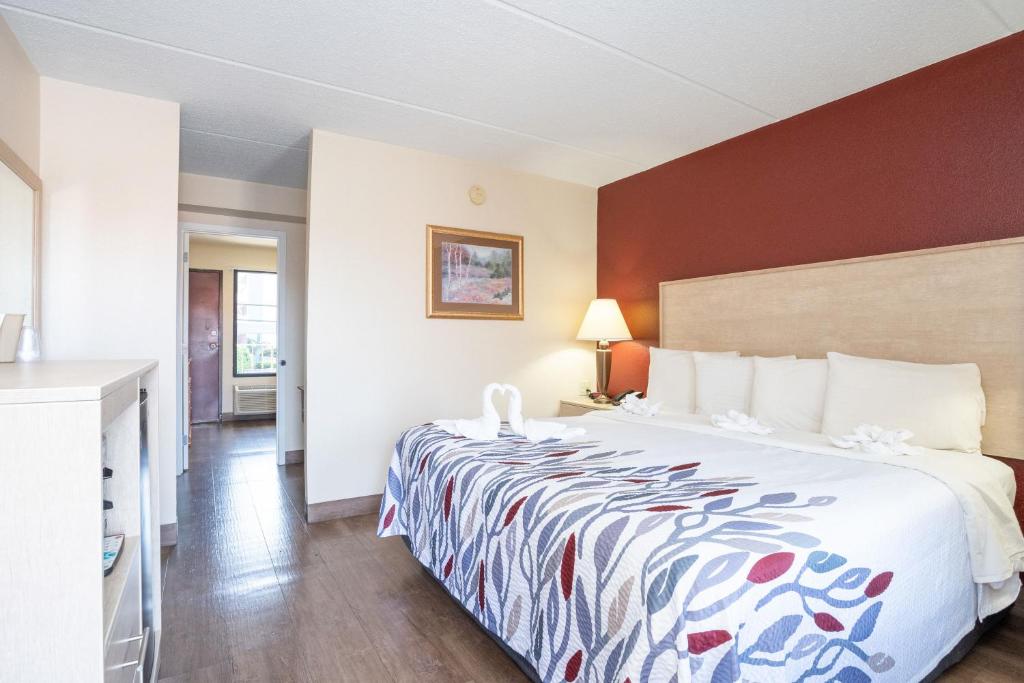 a hotel room with a bed with a colorful bedspread at Red Roof Inn & Suites Pigeon Forge Parkway in Pigeon Forge