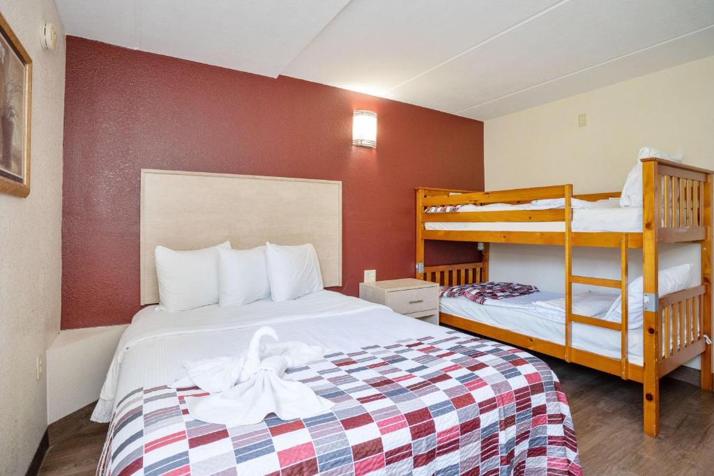 a small room with a bed and bunk beds at Red Roof Inn & Suites Pigeon Forge Parkway in Pigeon Forge