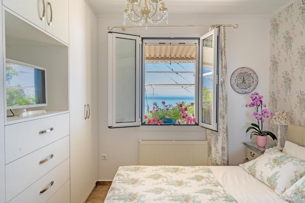 een slaapkamer met een bed en een raam bij MARIOS VILLAS in Póros