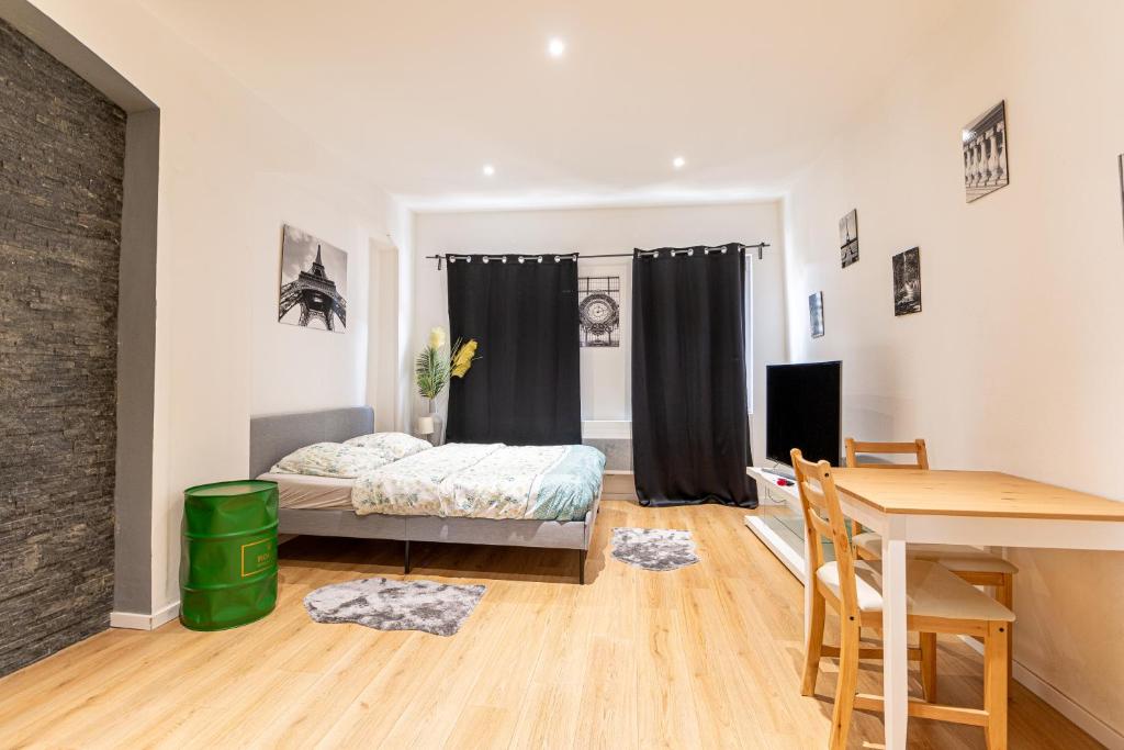 a bedroom with a bed and a desk and a table at Studio HyperCentre Strasbourg in Strasbourg