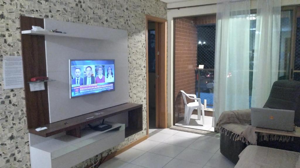 a living room with a flat screen tv on a wall at Residence 207 Cabo Branco in João Pessoa