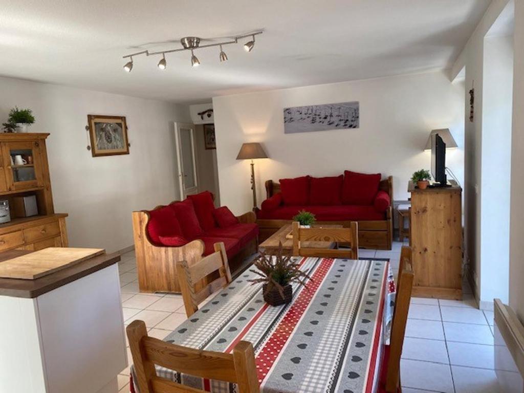 uma sala de estar com sofás vermelhos e uma mesa em Appartement Brides-les-Bains, 3 pièces, 6 personnes - FR-1-512-148 em Brides-les-Bains