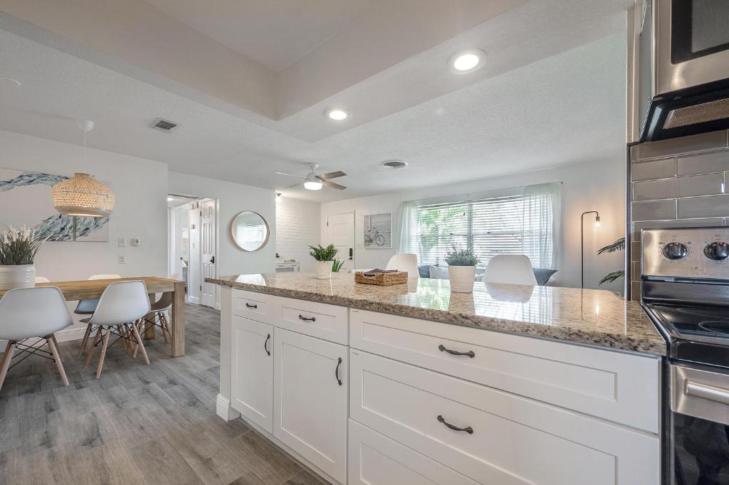 a kitchen with white cabinets and a dining room at Upgraded Seminole home in a quiet neighborhood in Seminole