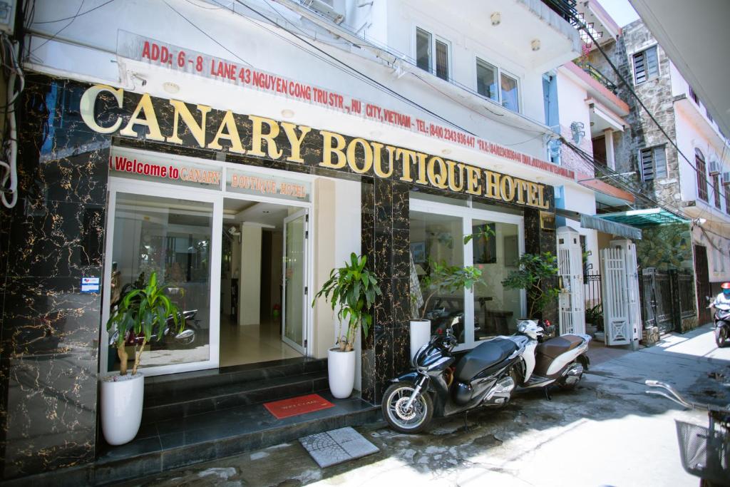 uma moto estacionada em frente a um edifício em Canary Boutique Hotel em Hue