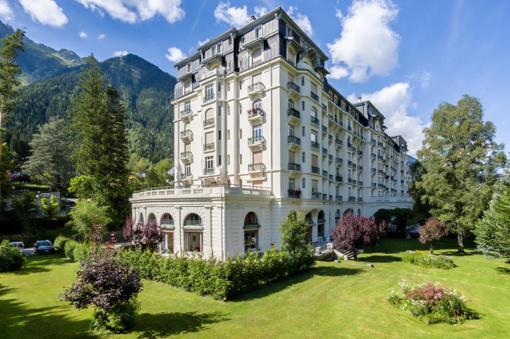 ein großes weißes Gebäude auf einem grünen Rasen in der Unterkunft Le Majestic 145 Appt - Chamonix All Year in Chamonix-Mont-Blanc