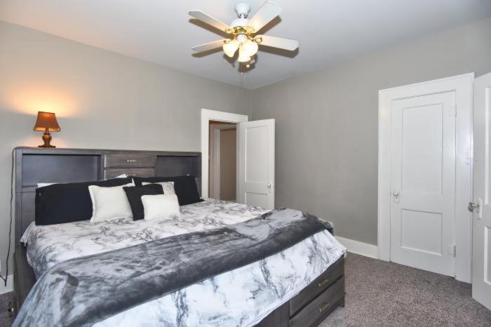 a bedroom with a large bed with a ceiling fan at ENTIRE HOME*CHERRY ST*FOOD*FUN*DRINKS*SHOP* in Tulsa
