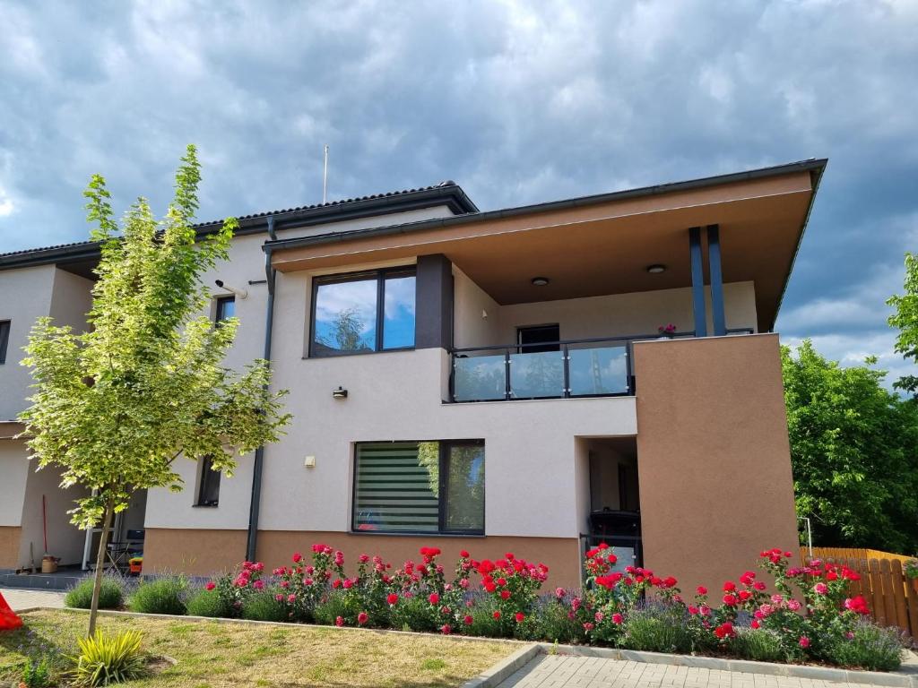 a house with a balcony and some flowers at Lotus Apartman II in Odorheiu Secuiesc