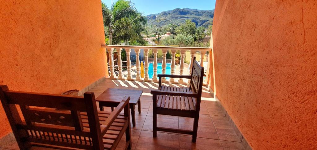 un balcone con tavolo, sedie e piscina di Pousada Flor De Lótus Cipo a Serra do Cipo