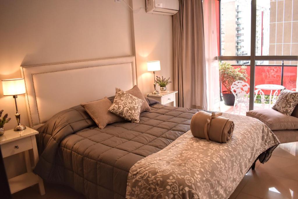 um quarto com uma cama e uma grande janela em Departamento de los Boulevares em Córdova