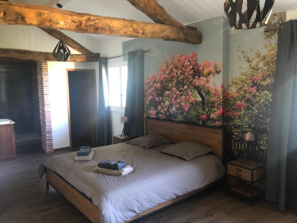 Schlafzimmer mit einem Bett mit Wandgemälde in der Unterkunft Au Clair de la Pierre - Chambres d'hôtes in Siccieu-Saint-Julien-et-Carisieu