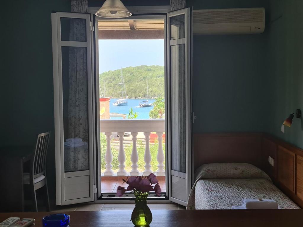 a bedroom with a large glass door to a balcony at Edem Studios in Syvota
