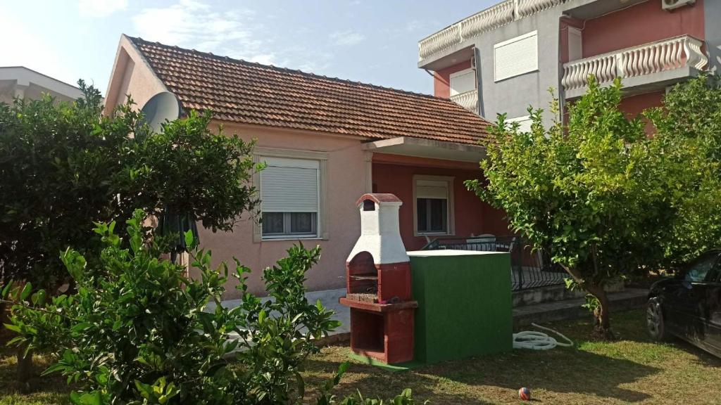 a house with an old gas pump in front of it at Lemon Tree in Ulcinj