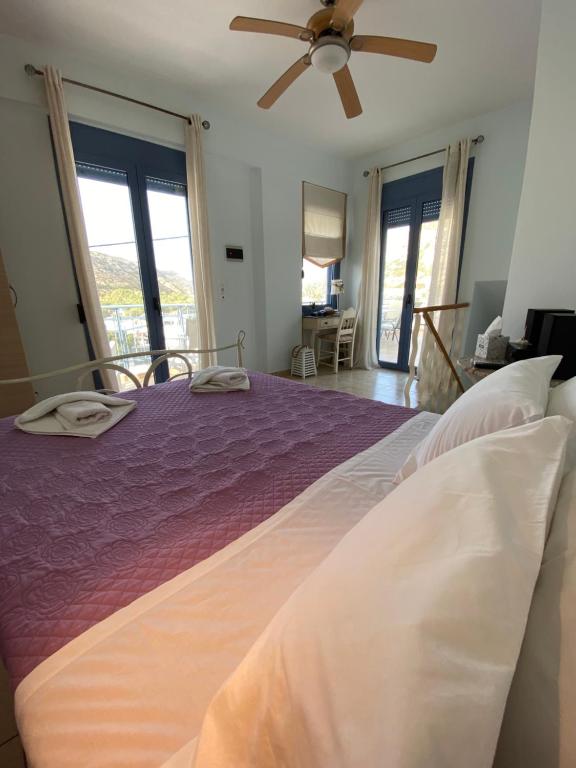sypialnia z fioletowym łóżkiem i wentylatorem sufitowym w obiekcie Villa Red Beach - Matala Love w mieście Matala