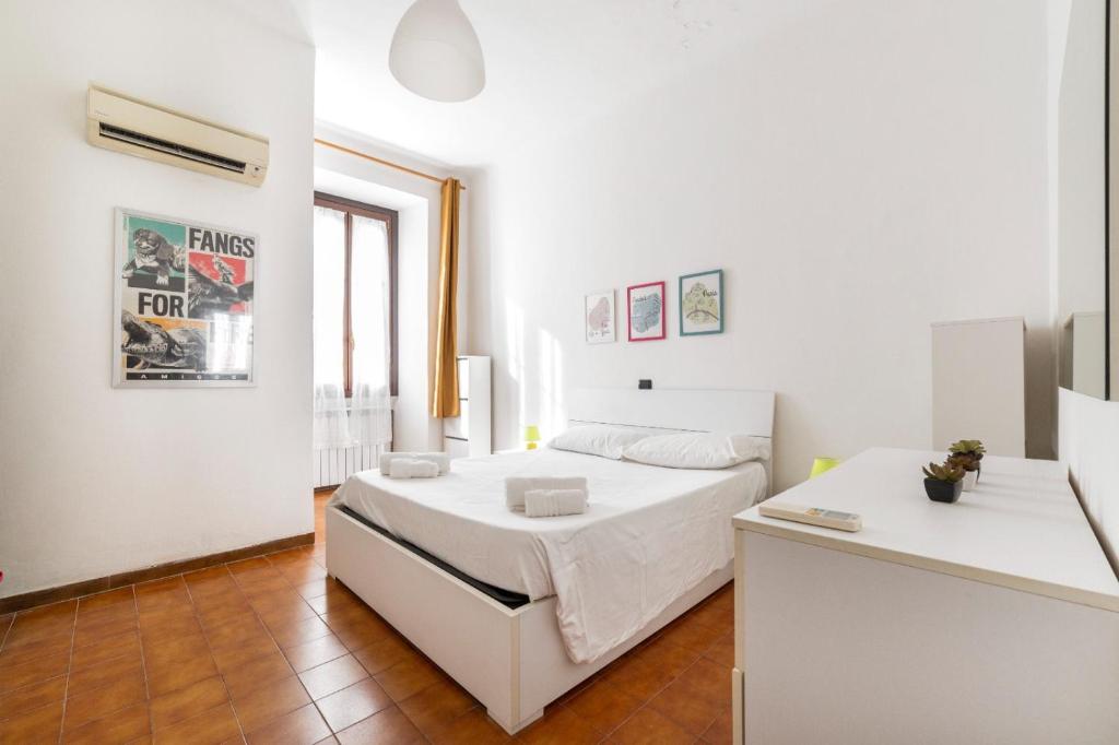 biała sypialnia z łóżkiem i biurkiem w obiekcie Cimiano Cozy Apartment w Mediolanie