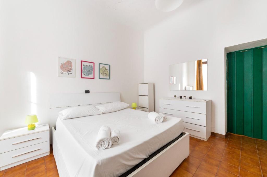 biała sypialnia z białym łóżkiem i zielonymi drzwiami w obiekcie Cimiano Cozy Apartment w Mediolanie