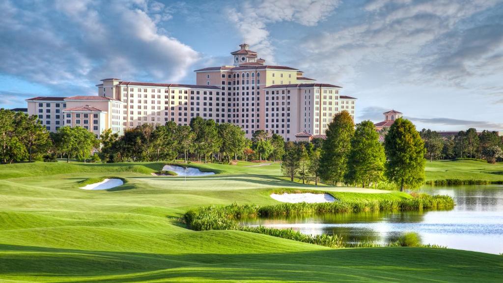 einen Golfplatz mit Hotel im Hintergrund in der Unterkunft Rosen Shingle Creek Universal Blvd in Orlando