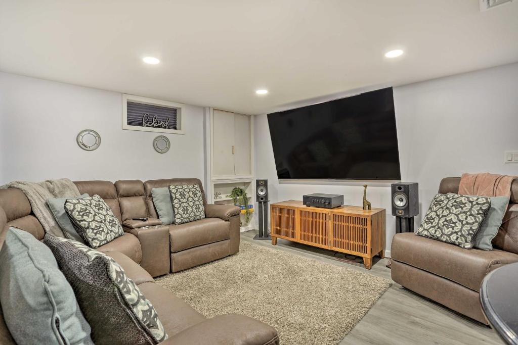 a living room with two couches and a flat screen tv at Saddle Brook Studio with Patio - Near NYC! in Saddle Brook