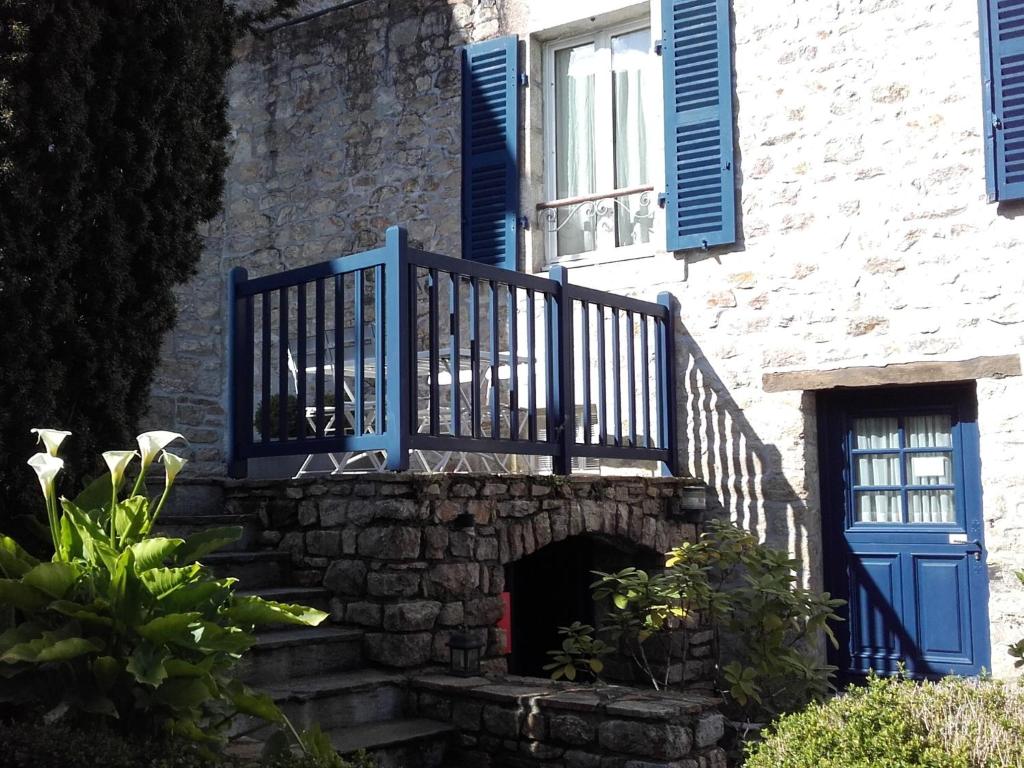 a stone building with a staircase and blue shutters at Résidence Ti An Amiral in Bénodet