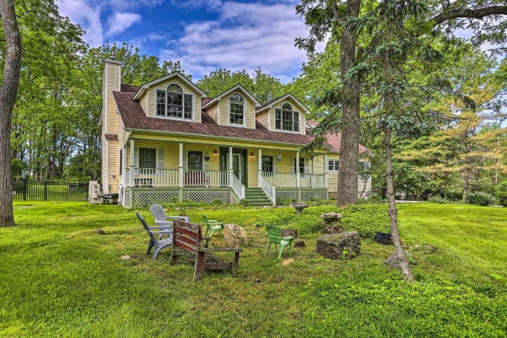 una casa amarilla con una mesa y sillas en el patio en Spacious Hudson Valley Gem on Private 2 Acres!, 