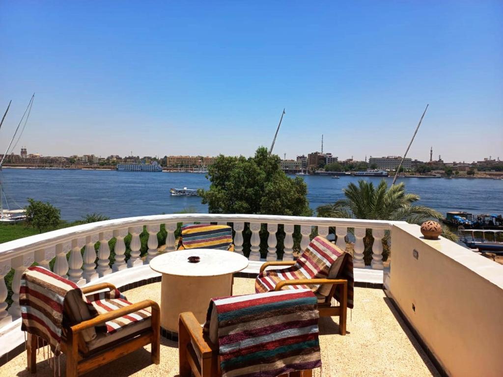 a patio with chairs and a table with a view of a river at Jasmine Villa in Luxor