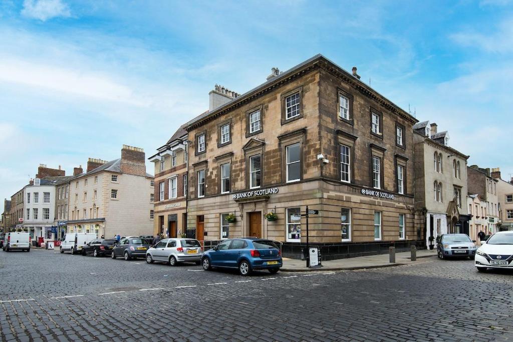 a building on a street with cars parked in front of it at Linen House in Kelso