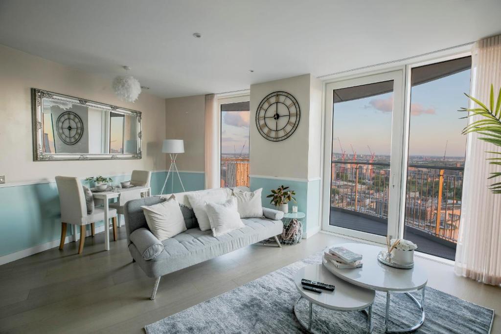a living room with a couch and a table at Amazing London City Skyline View & Transport Links in Barking