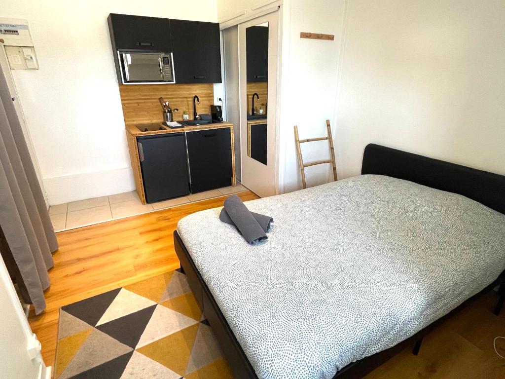 een kleine slaapkamer met een bed en een keuken bij Studio République Centre NETFLIX inclus in Orléans