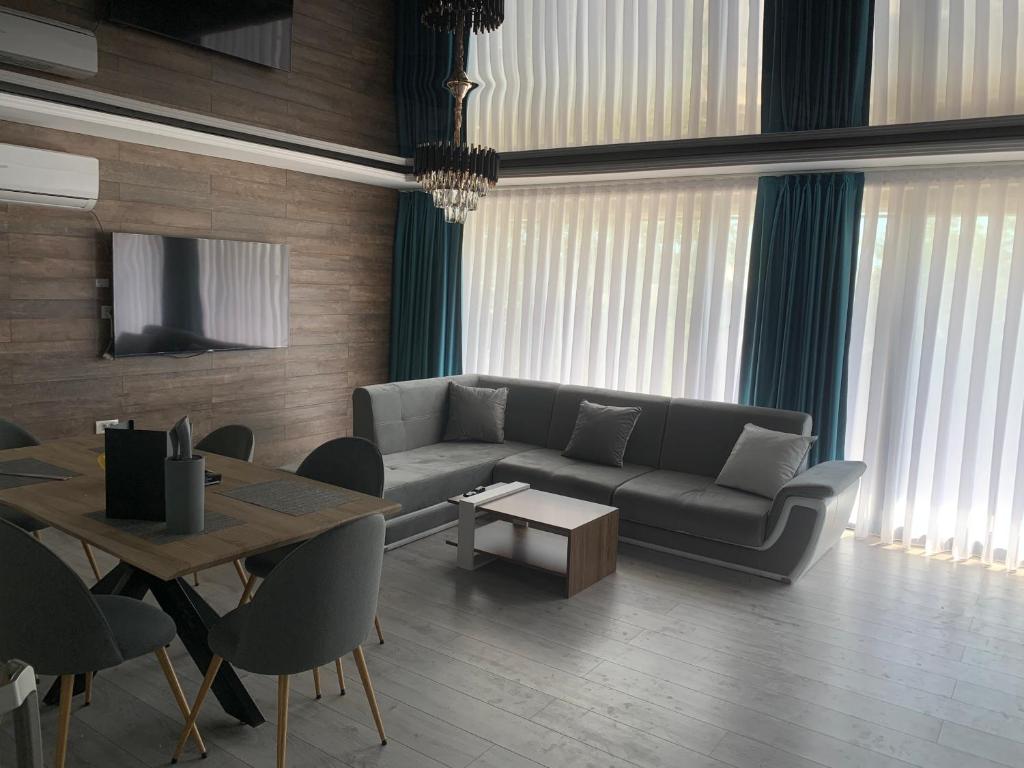 uma sala de estar com um sofá e uma mesa em Apartament Maya Lumina em Lumina