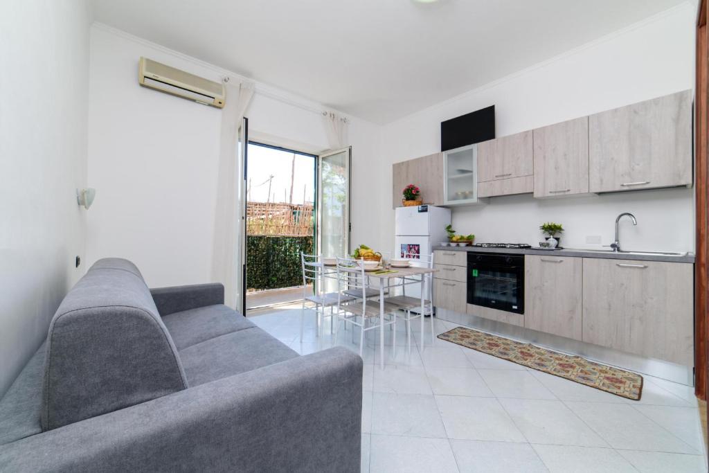 ein Wohnzimmer mit einem Sofa und einer Küche in der Unterkunft Estate4home - Sottovoce in Piano di Sorrento