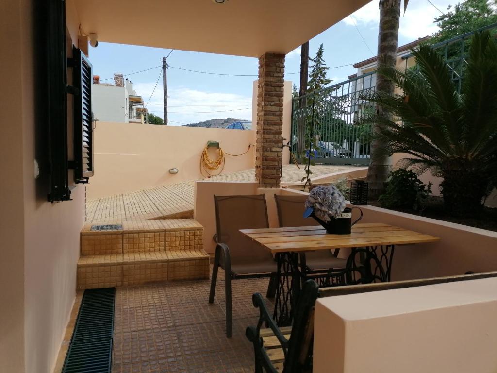 a patio with a wooden table and chairs on a balcony at petite nafplio sofos apartment in Nafplio