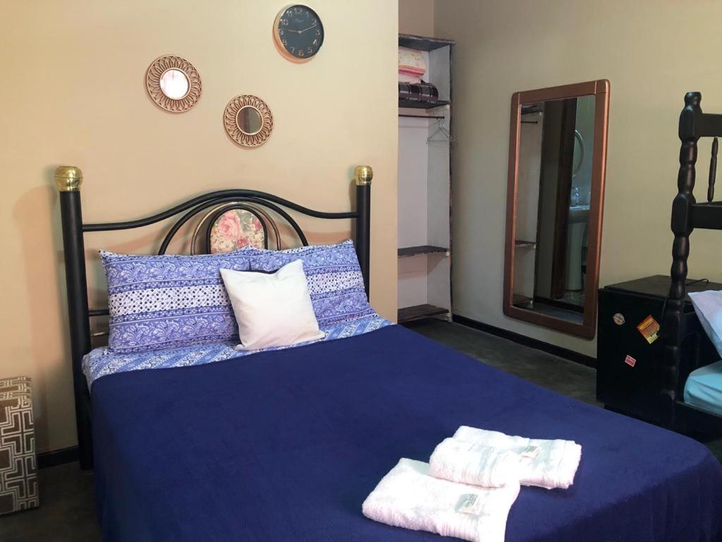 a bedroom with a blue bed with towels on it at Hostel Limão Doce in Nova Friburgo