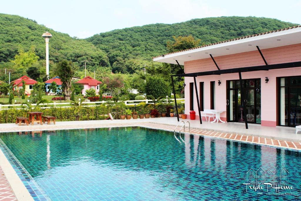 a swimming pool in front of a building at Triple P Home Resort in Pak Chong