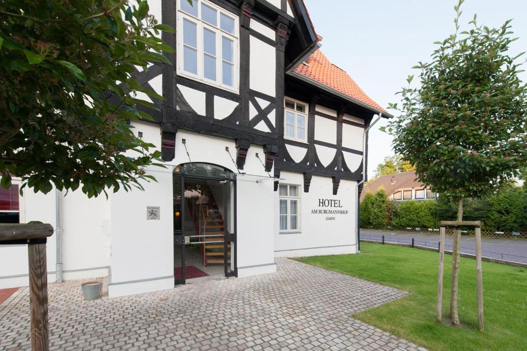 um edifício preto e branco com uma porta em Hotel Am Burgmannshof em Wunstorf