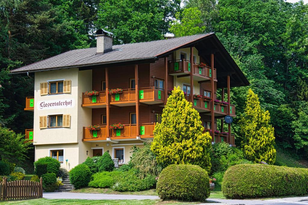 un grande edificio con balconi, alberi e cespugli di Pension Liesertalerhof a Trebesing