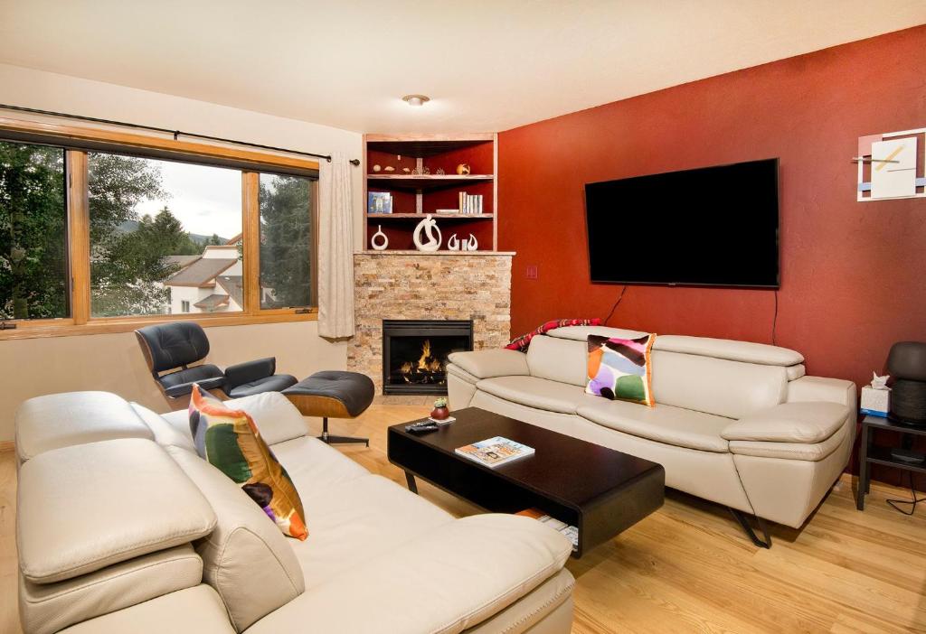 a living room with white couches and a flat screen tv at Greenbrier Townhouse 36 in Avon