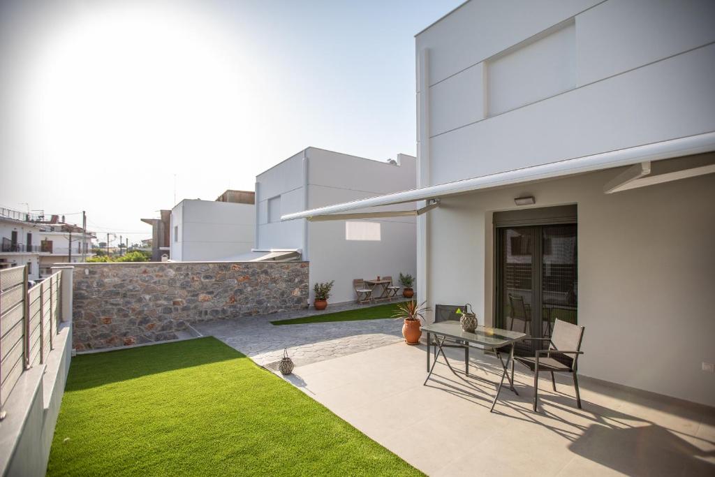 a patio with a table on the roof of a house at Amarynthos Maisonettes in Amarynthos