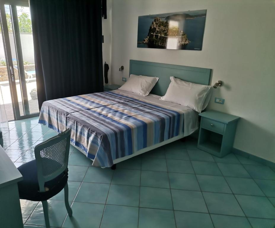 una piccola camera con letto e sedia di Residenz e Ristorante da Mimì a Ischia