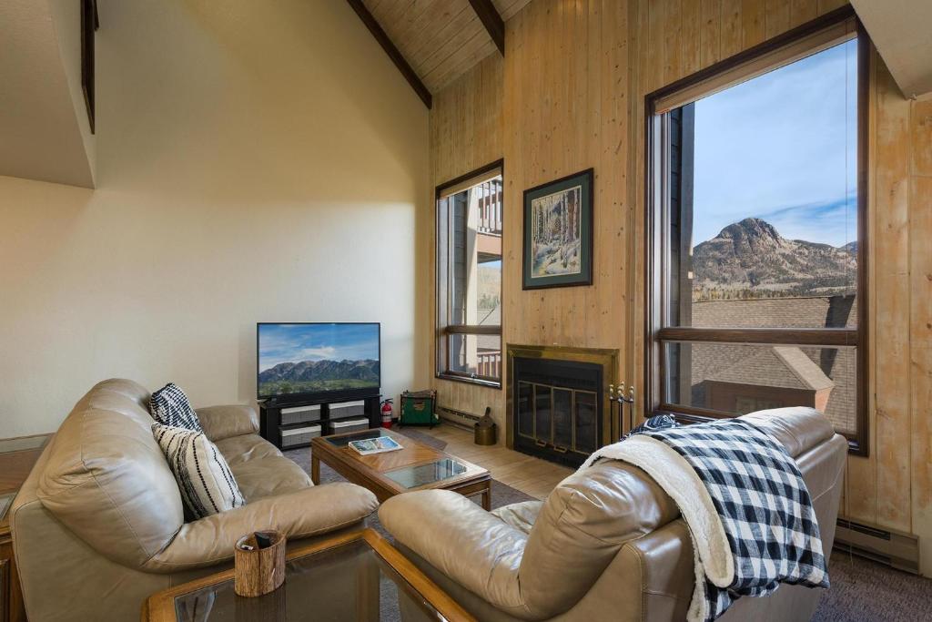 a living room with leather furniture and a large window at Cascade Village 50 Near Purgatory - Marmot Meadows Retreat in Durango Mountain Resort