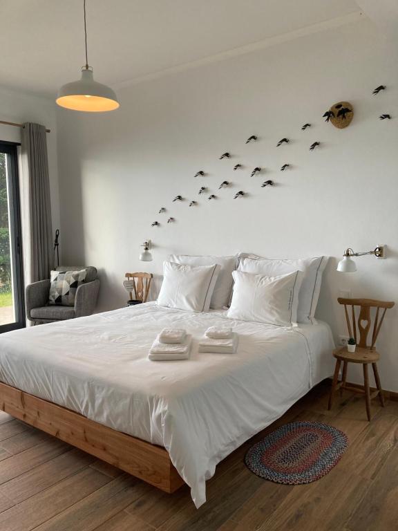 a bedroom with a large white bed with fish on the wall at Casa de Santo Amaro in Santo Amaro