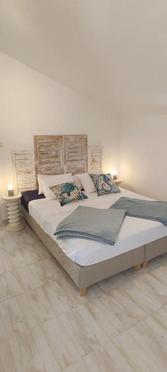 a large bed in a bedroom with two lamps at Appartements Dominique, with private terrace in Supetarska Draga