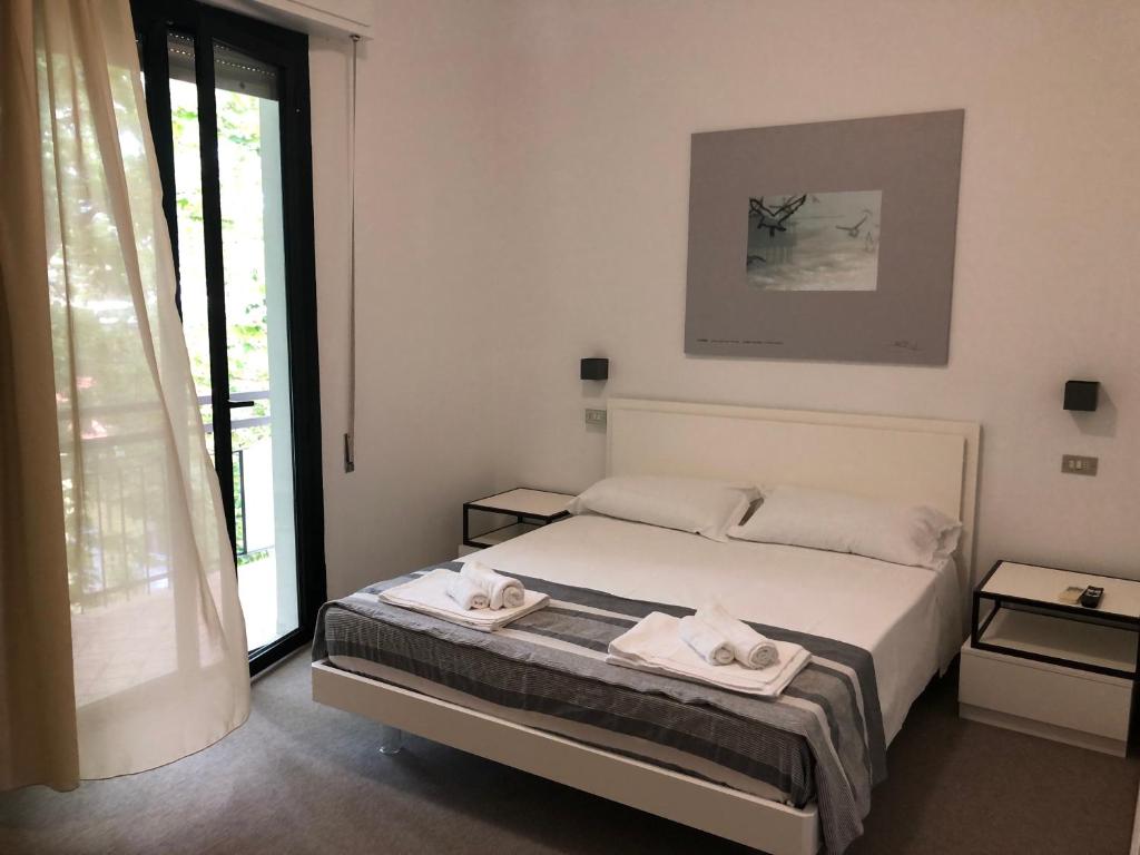 a bedroom with a bed with two towels on it at Vinsea Hotel in Bellaria-Igea Marina