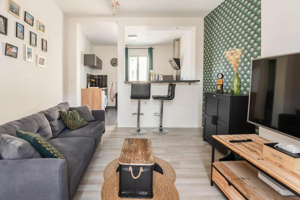 a living room with a couch and a tv at Appart'LH - Stationnement gratuit - B'PAM in Le Havre