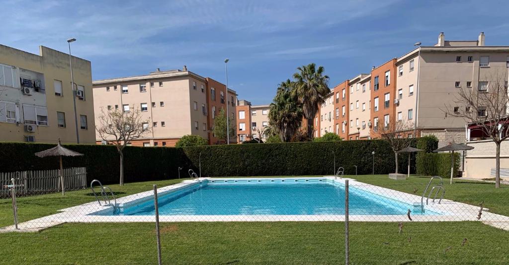 a swimming pool in a park with some buildings at Apartamento Oslo - Excelente conexión a playas in Jerez de la Frontera
