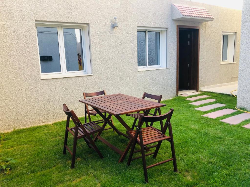 een picknicktafel en twee stoelen in het gras bij NEAPOLIS STUDIO in Nabeul