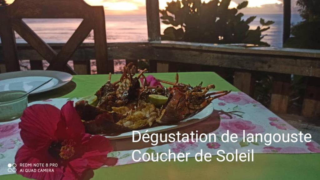 talerz jedzenia na stole z kwiatem w obiekcie Hotel Le Sultan w mieście Moya