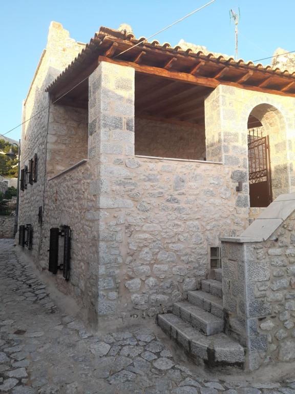 a stone building with a gate and stairs outside at Stonehouse in Mani Penisula in Koíta