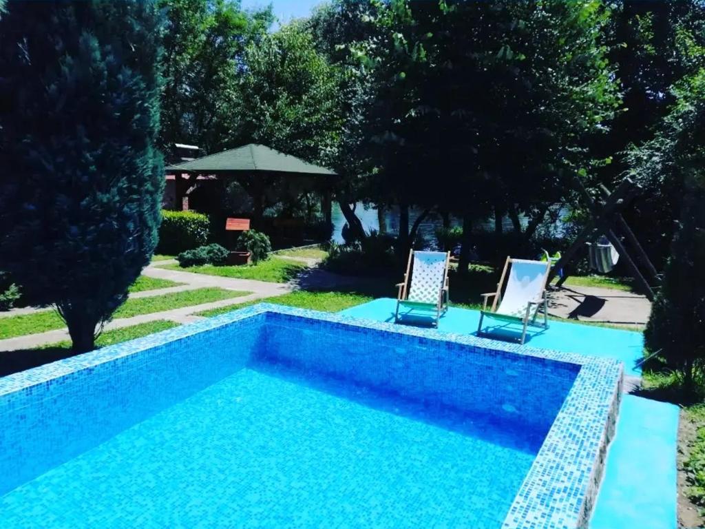 a swimming pool with two lawn chairs and a swimming pool at Vikendica Pavle in Vrhpolje