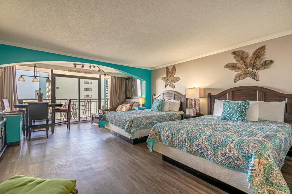 een hotelkamer met 2 bedden en een eetkamer bij Ocean View Double Queen Suite! - Caravelle Resort 508 - Sleeps 4 Guests! in Myrtle Beach