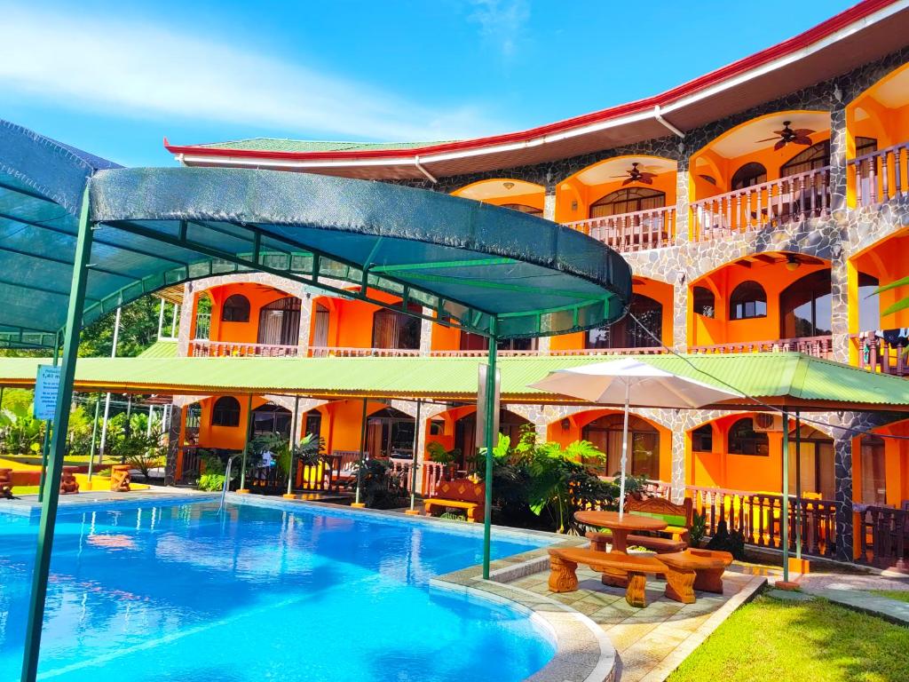 een hotel met een zwembad voor een gebouw bij Apartahotel Playa Luna in Uvita