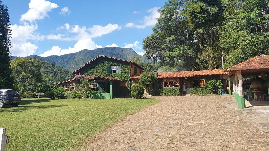 ein Haus mit einem Rasenplatz davor in der Unterkunft Fazenda pedra selada in Visconde De Maua